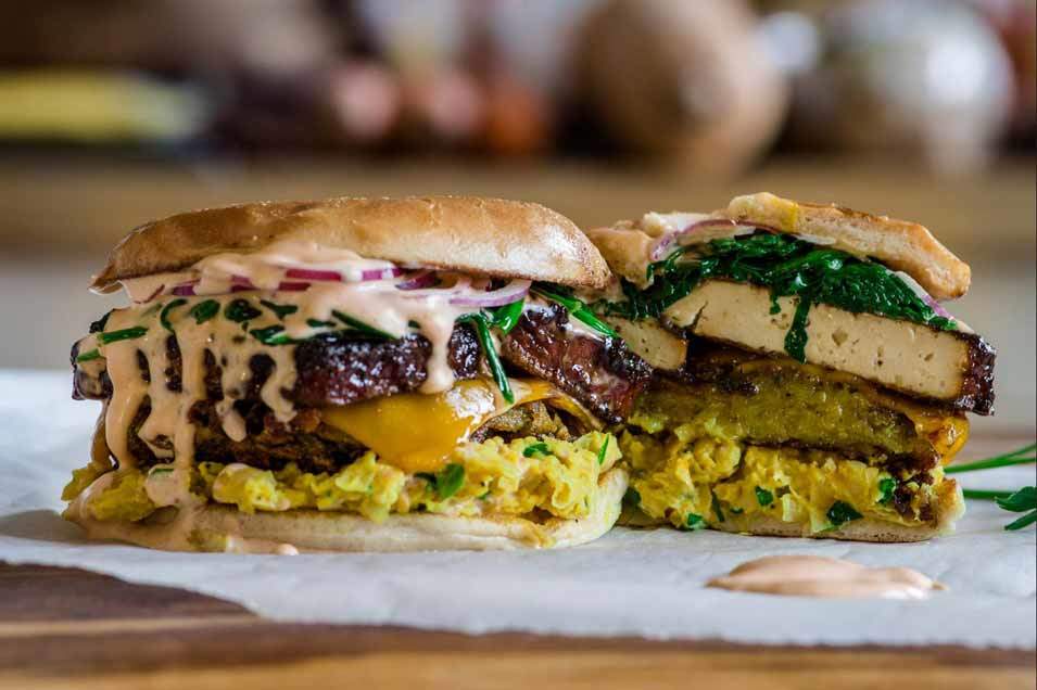 vegan breakfast sandwich with smokey tofu bacon, hash, chickpea eggs