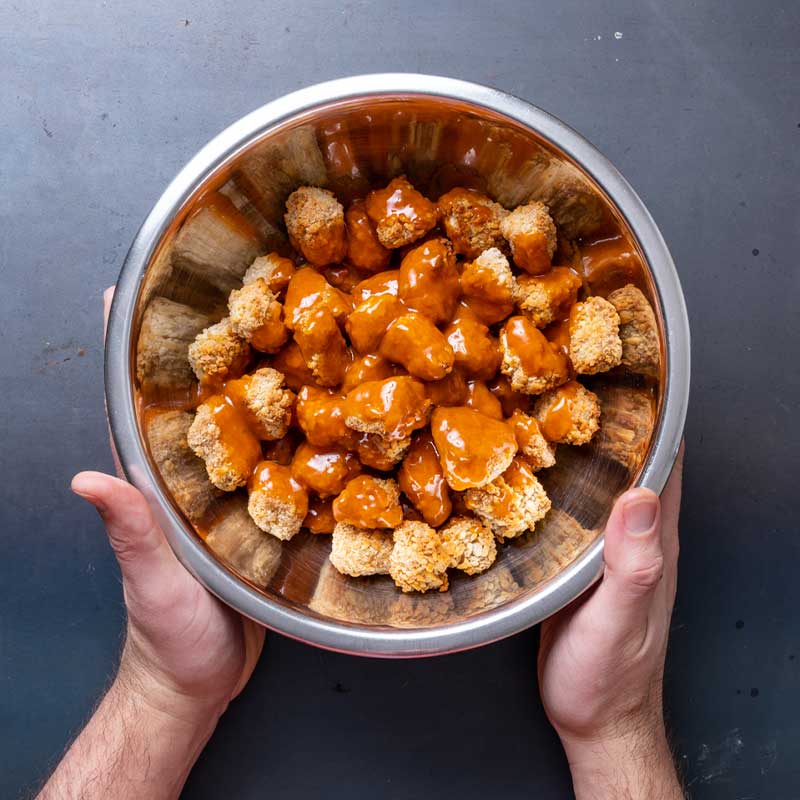 tossing buffalo tofu wings